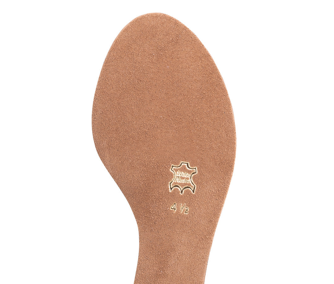 Close-up of a suede shoe sole with embossed logo and size 4½ marking, highlighting quality craftsmanship.