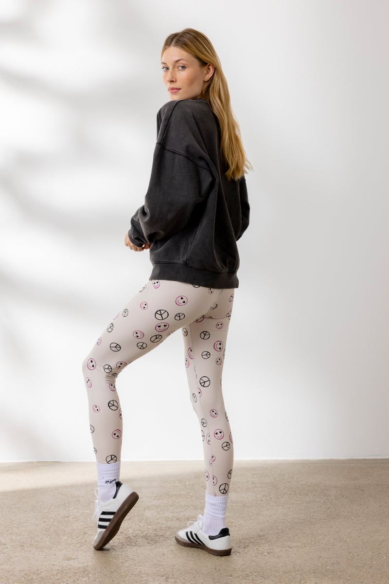 Model wearing Hey Honey Yoga "Peace Sweater" with stylish peace print leggings, perfect for yoga and casual wear.