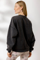 Woman wearing Hey Honey Yoga Sweater Peace in black, showcasing casual style with comfortable fit and positive message.