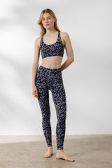 Model wearing Hey Honey Criss-Cross Bra and leggings in Distorted Animal Magnet print, ideal for yoga and fitness.