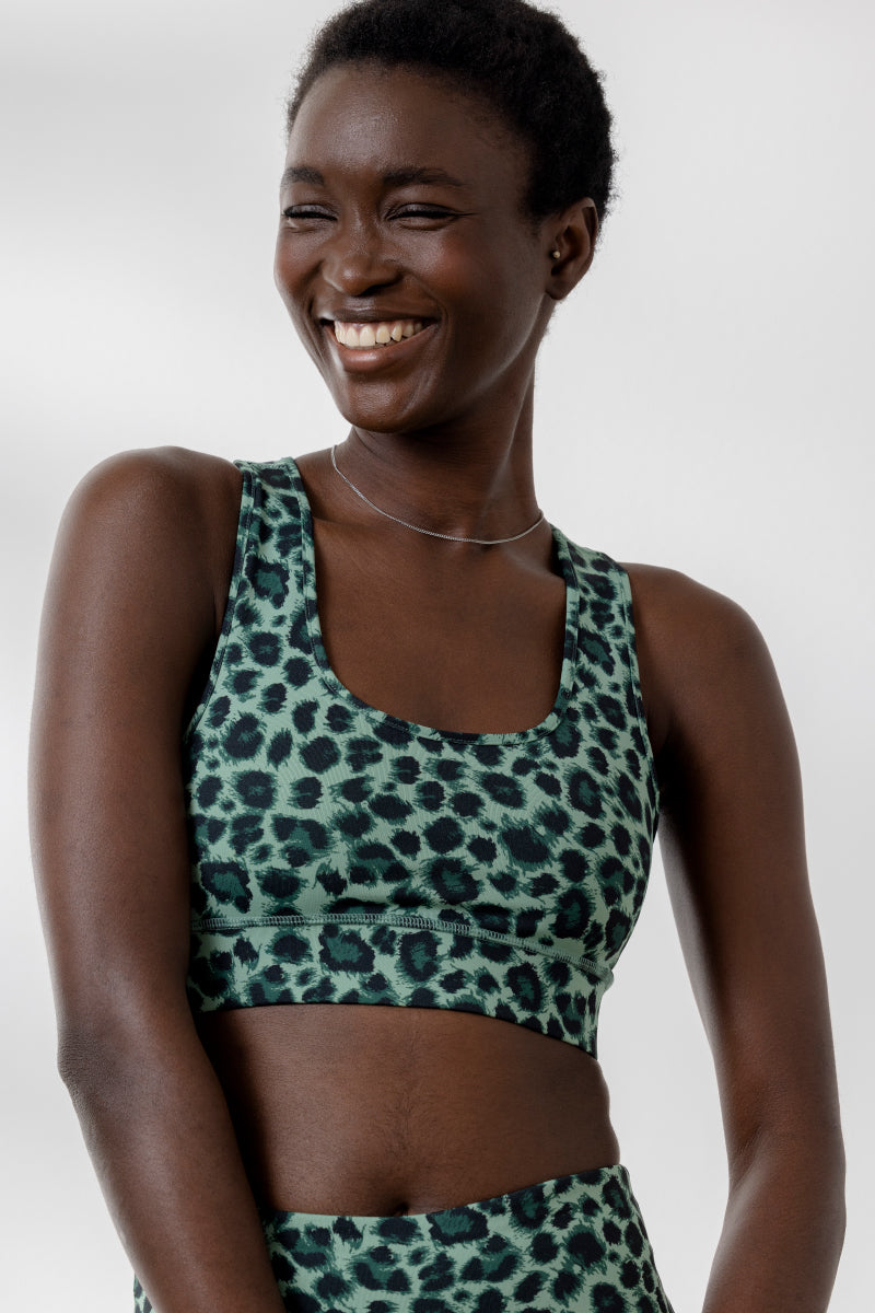 Model wearing the Bra Leo Jade from Hey Honey Yoga, featuring a breathable, supportive design in a leopard print.