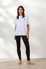 Model wearing an oversized white T-shirt with a heart print, paired with black leggings featuring red hearts.