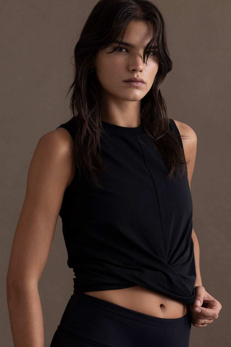 Model wearing a cropped black top made from soft, breathable fabric, perfect for yoga or casual outings.