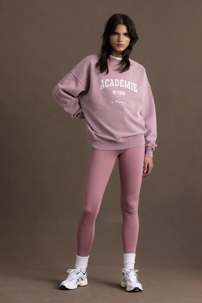Model wearing a cozy Academie Rose sweater with leggings, showcasing a stylish casual look.
