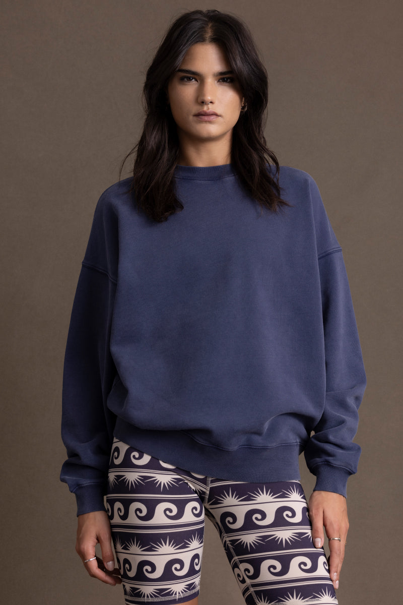 Model wearing a comfortable navy blue sweater with a relaxed fit, paired with stylish patterned leggings.