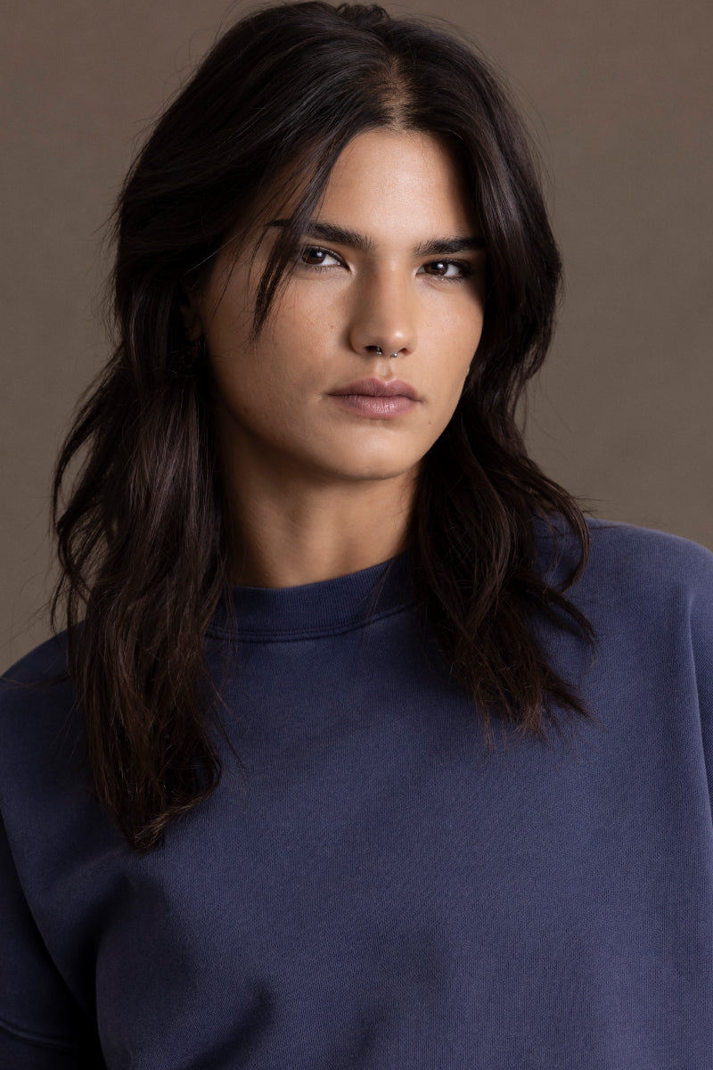 Model wearing a comfortable navy sweater with a modern design, showcasing a relaxed fit and classic round neckline.