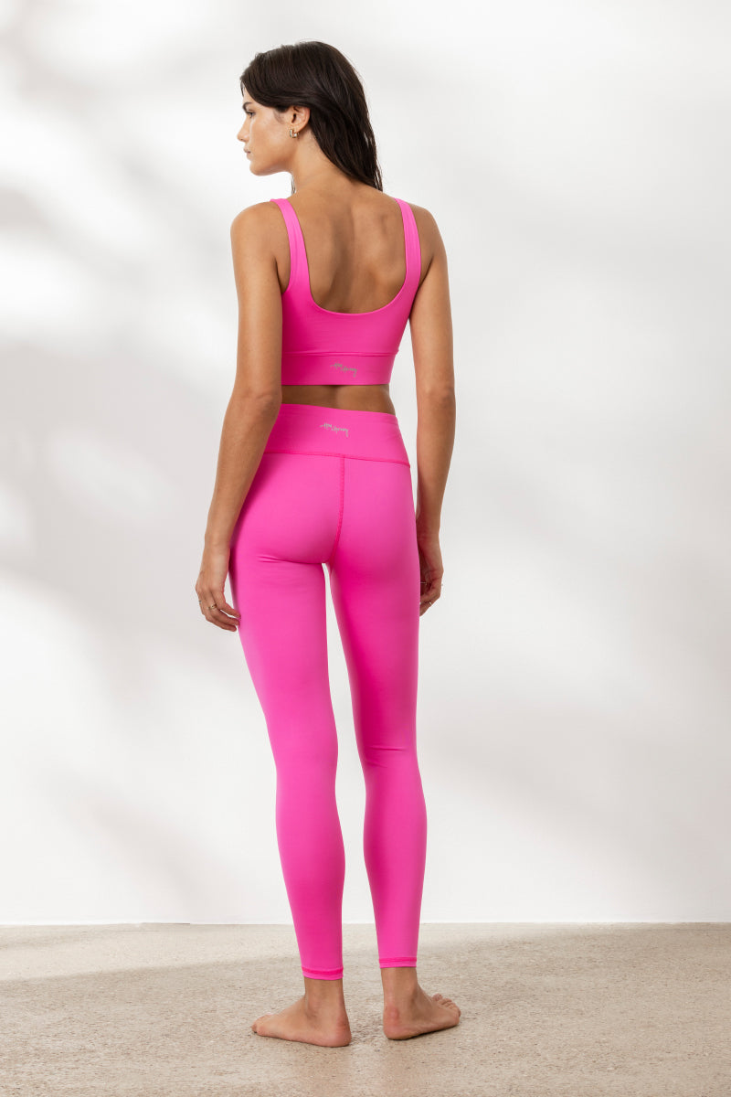 Model wearing Hey Honey Yoga neon pink leggings and matching top, showcasing a stylish, athletic look from the back.