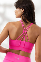 Criss-cross design of Hey Honey Yoga's neon pink bra, showcasing back support and stylish look for active wear.