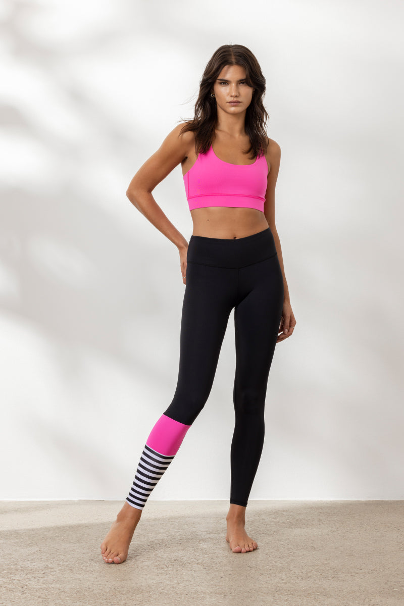 Model wearing Hey Honey Surf Style Neon Pink leggings and matching sports bra, showcasing vibrant design for yoga and fitness.