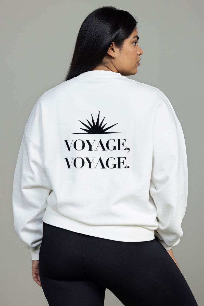 Off-white sweater featuring "VOYAGE, VOYAGE." graphic on back, designed for comfort and casual wear.