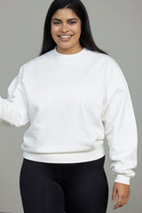 Model wearing the Trui Voyage Off-White sweater, showcasing its comfortable fit and casual style. Perfect for everyday wear.