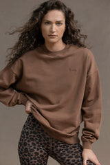 Model wearing a relaxed fit cocoa sweater with leopard print leggings, showcasing comfort and style.