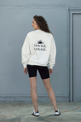 Model wearing the Trui Voyage Off-White sweater, showcasing its relaxed fit and stylish back design.