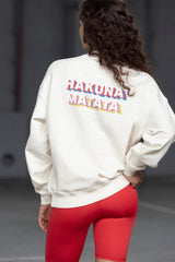Back view of a woman wearing a cream sweatshirt featuring colorful "Hakuna Matata" text, paired with red leggings.