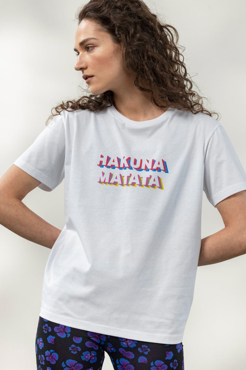 Woman wearing a comfortable white shirt with "Hakuna Matata" text for a playful and carefree style.