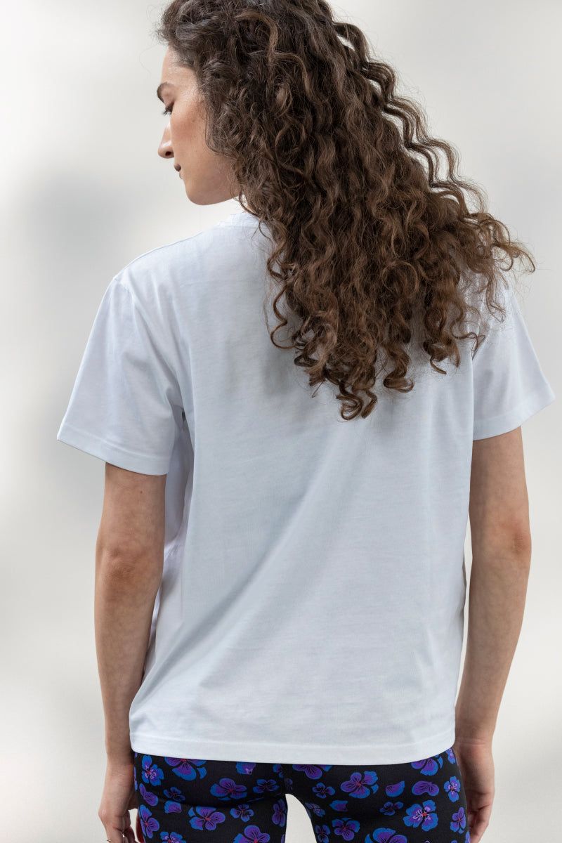 Woman wearing a white Hakuna Matata t-shirt, showcasing a casual and comfortable style from the back.