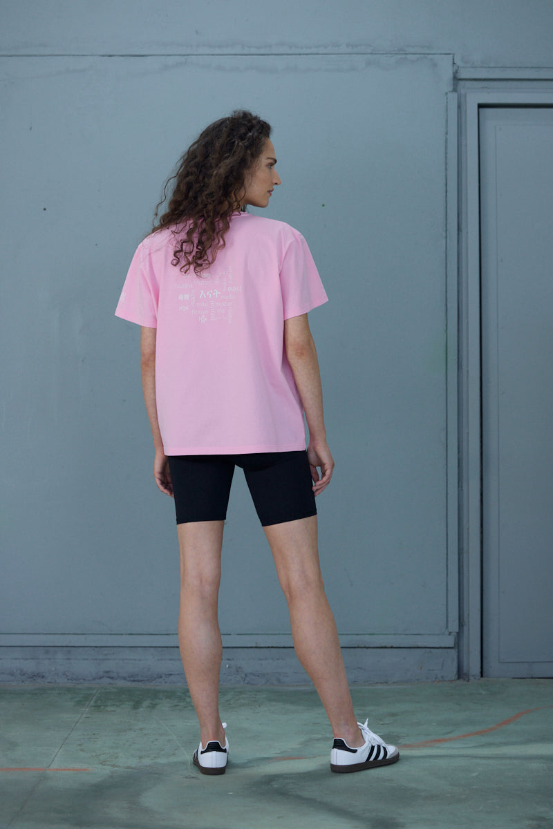 Woman wearing a pink "Mother" T-shirt with black shorts, showcasing a stylish and casual look from the back.