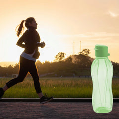 Woman jogging at sunset with a Tupperware EcoEasy 500 ml bottle beside her, showcasing its ergonomic design and portability.