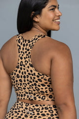 Woman in racerback leopard print bra, highlighting comfort and style for yoga and fitness activities.