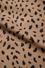 Close-up of brown fabric with black leopard print, showcasing the texture and pattern for activewear design.