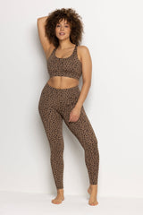 Stylish model wearing brown leopard print leggings and matching crop top, showcasing comfort and modern design for activewear.