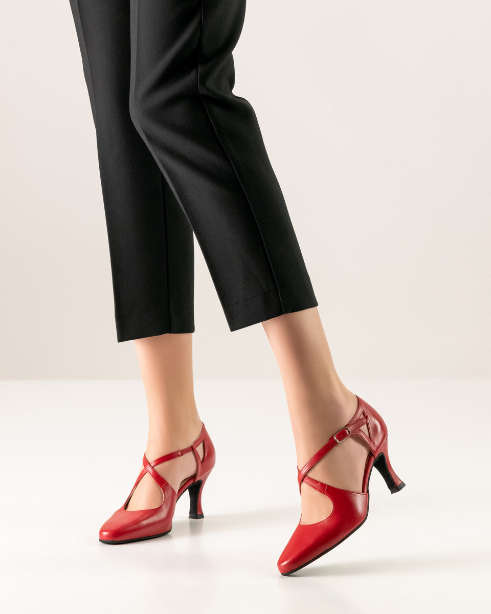 Elegant red Werner Kern "Ines" dance shoes with double T-straps and adjustable ankle bands, styled with black pants.